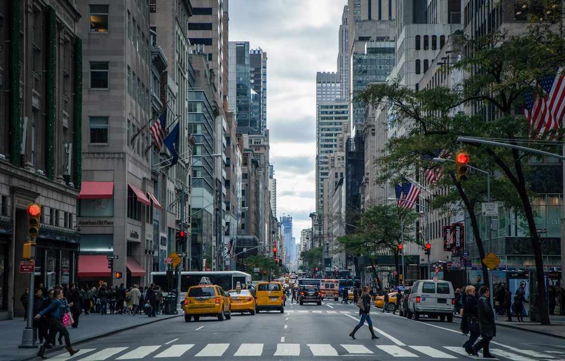 Imagem de avenida com táxis e pedestres em Nova York em artigo sobre quanto custa uma viagem para os Estados Unidos.