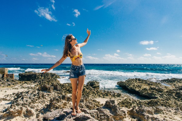 Mujer posando en las rocas de la playa de Gaviota en Cancún.