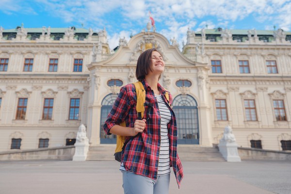 Turista con mochila disfrutando de un paseo cerca del complejo del palacio Belvedere, Viena, en un día soleado