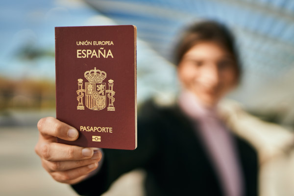 Persona irreconocible mostrando a cámara pasaporte español 