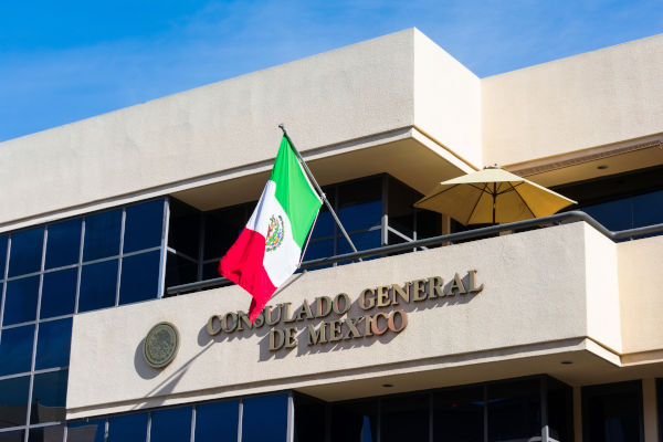 Exterior de un Consulado General de México con la bandera de México en el frente.