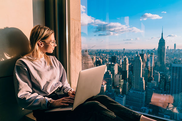 Mujer trabajando con computadora portátil en un edificio de Nueva York