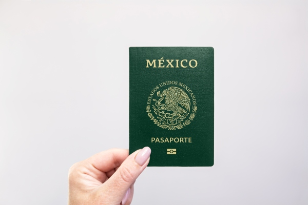 Persona que sostiene un pasaporte mexicano, que es uno de los requisitos para la visa de turista.