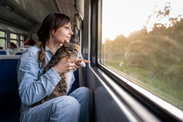 Mujer sosteniendo a su gato en un viaje en tren.