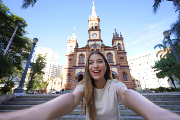 Turista sacándose una selfie frente a la iglesia São José en el centro de Belo Horizonte.