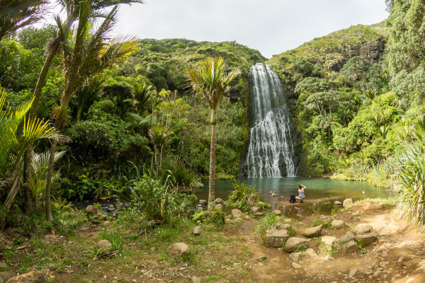 Personas bañándose cerca de una de las cascadas Karekare, Waitakere Ranges Regional Park, Nueva Zelanda.