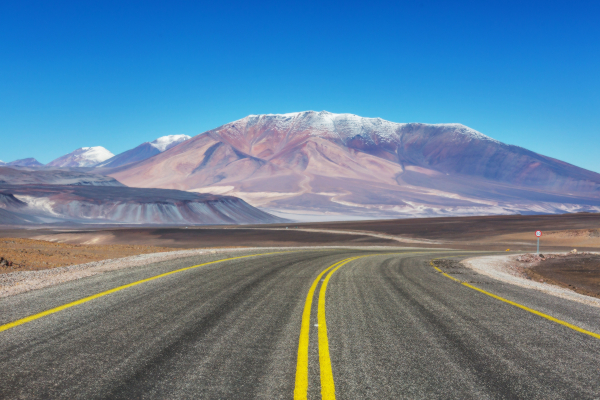 Camino asfaltado en una ruta de alta montaña hacia un paso fronterizo entre Argentina y Chile.