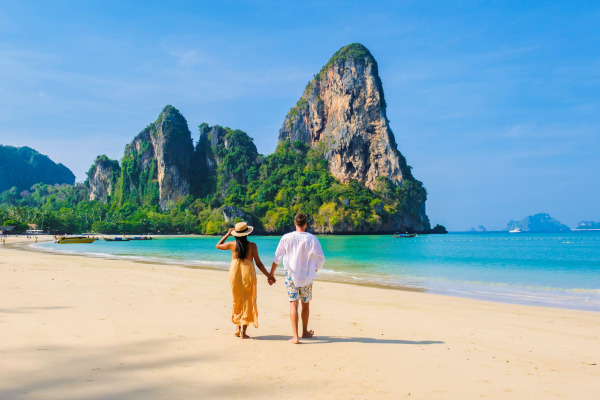 Pareja caminando de la mano en la Railay Beach en Tailandia en un día soleado.