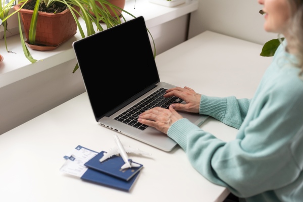 Mujer que saca un turno en Mi Argentina desde su laptop para renovar pasaporte argentino.