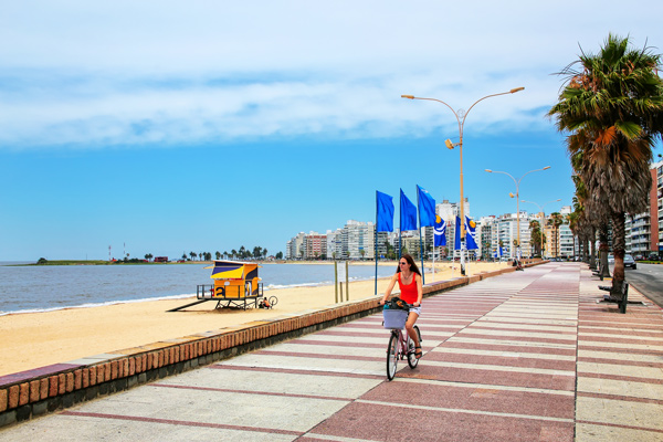 Chica andando en bicicleta en la costanera de Montevideo