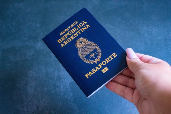 Persona sosteniendo un pasaporte argentino, una de las que necesitas para viajar a Europa desde Argentina.
