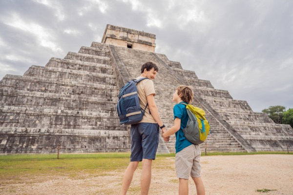 Padre e hijo visitan el Chichén Itzá en México, uno de los lugares para viajar en familia.