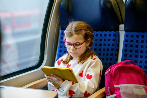 Niña con permiso para viajar menores, viajando en un tren de larga distancia.
