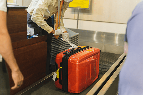 Funcionário de aeroporto etiquetando bagagem despachada