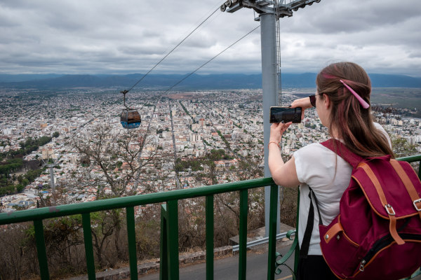 Mujer turista tomando una foto del teleférico del Cerro San Bernardo en Salta, Argentina.