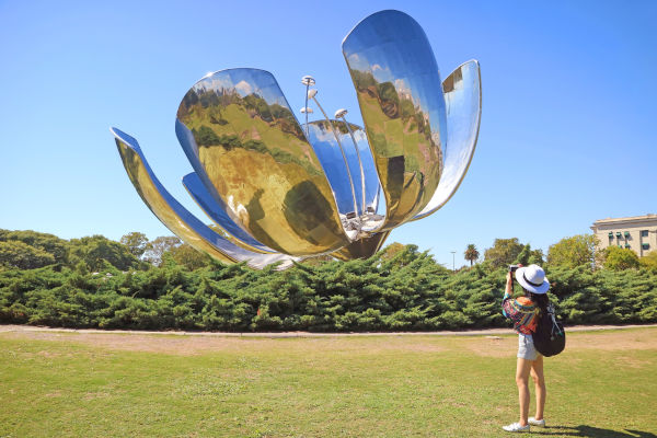 mujer turista tomando una foto de la Floralis Generica en Recoleta, Argentina.