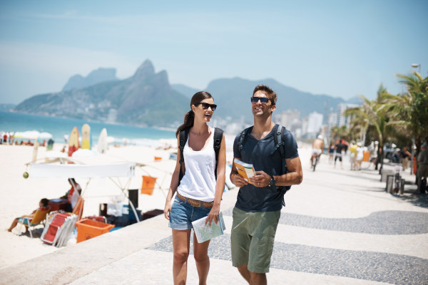 Pareja feliz caminando por las cercanías de la playa de Copacabana en Río de Janeiro en un día soleado