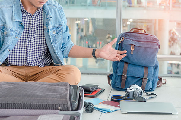 Hombre en aeropuerto buscando algún objeto perdido u olvidado con expresión de frustración