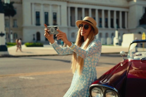 Mujer turista tomando una foto con su celular con conexión a internet en la ciudad de La Habana, Cuba.