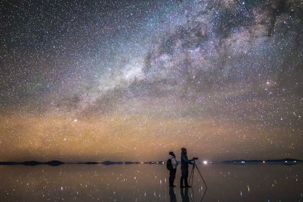 pareja observando las estrellas en la noche del Salar de Uyuni.