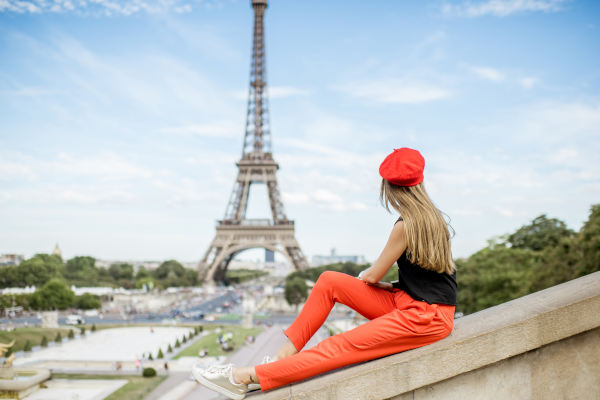 Mujer joven con gorra roja disfrutando de la vista a la Torre Eiffel en París.
