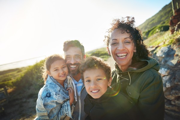 Familia tipo disfrutando de un viaje en las montañas en un día soleado.