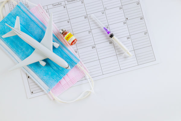 imagen con un calendario, un avión y una vacuna.