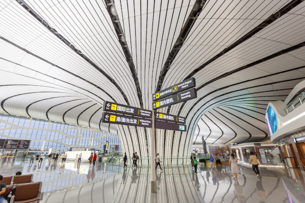 Interior del Aeropuerto de Daxing con carteles de guía en chino e inglés, Beijing, China.