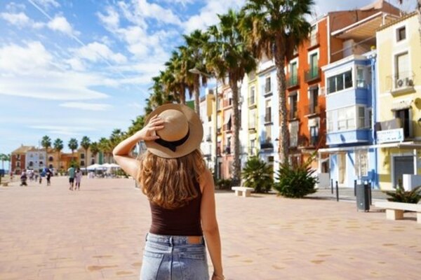 Una mujer de espaldas mirando unas casas coloridas en Alicante