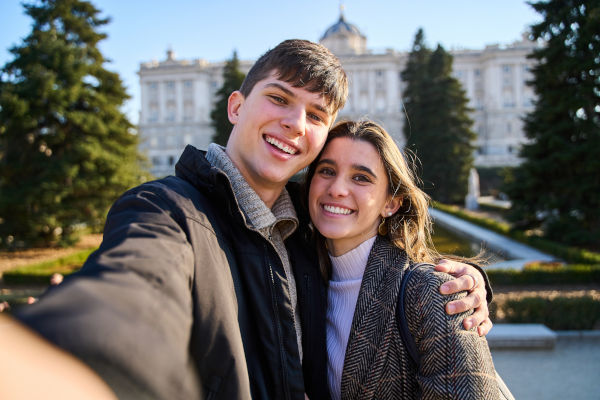 Pareja turista posa con el Palacio Real de Madrid, España.