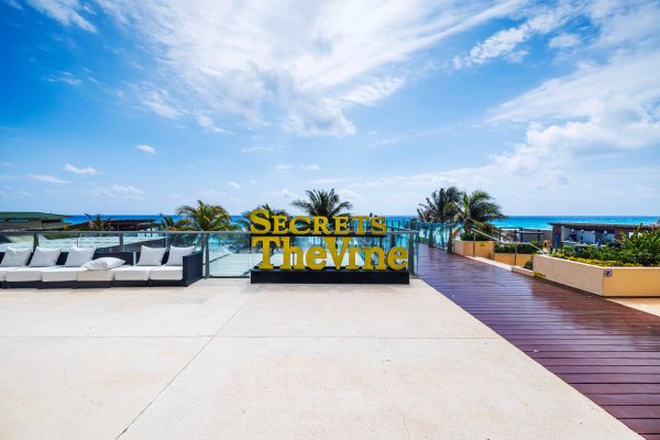 Zona de piscinas con vista al mar del hotel Secrets The Vine Cancún.