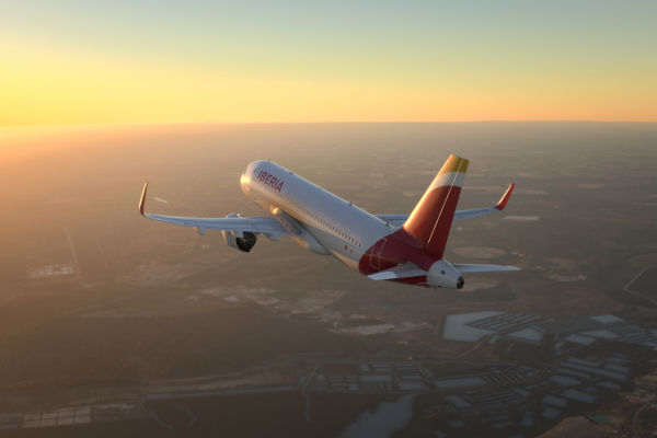 Avión de Iberia volando a gran altitud con cielo despejado de fondo.