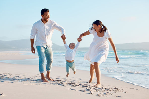 Familia latina recorriendo una playa paradisíaca.