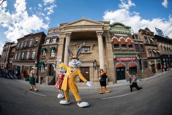 Personajes de Looney Tunes bailando en el medio de una calle.