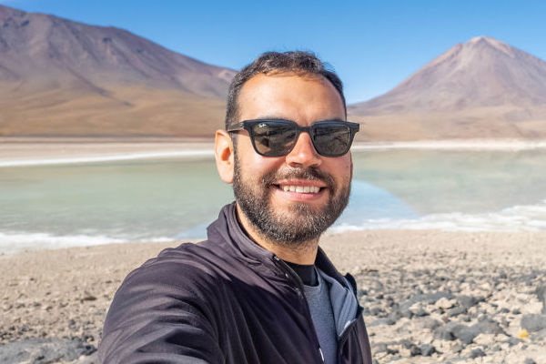 Hombre viajero tomando un selfie frente a Laguna Honda, Bolivia.