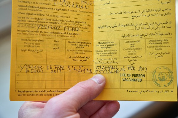 Persona que sostiene un certificado de vacunación contra la fiebre amarilla