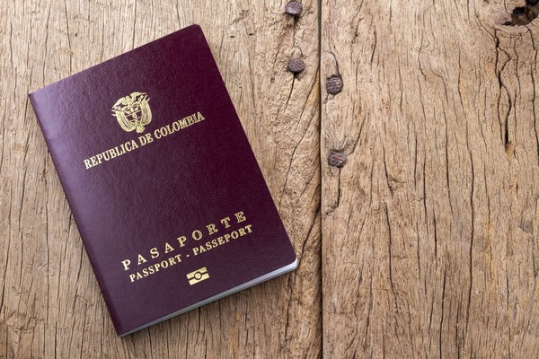 Pasaporte colombiano sobre una mesa de madera.