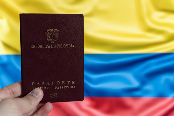 Persona que sostiene su pasaporte colombiano, que ya averiguó cuánto cuesta el pasaporte en Colombia.