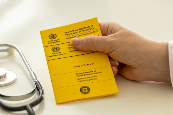 Doctor que sostiene en su mano un carnet de fiebre amarilla.