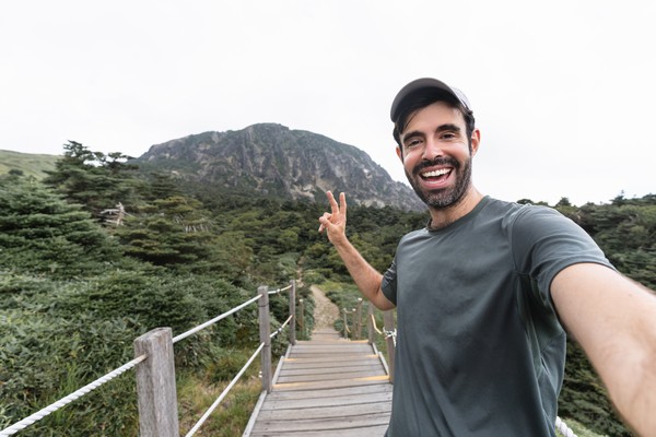 Hombre turista se toma una selfie en el sendero del volcán de Hallasan de la isla de Jeju, Corea del Sur.
