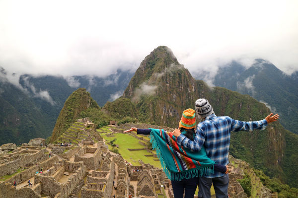 Pareja admirando las espectaculares vistas de Machu Picchu, Región del Cusco, Provincia de Urubamba, Perú.