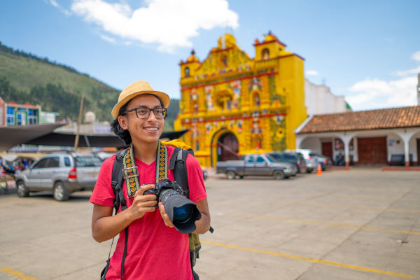 Joven turista con cámara fotográfica profesional en antigua ciudad colonial en Guatemala.