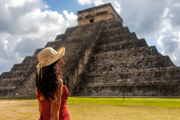 Mujer con las ruinas mayas de Chichen Itza en el contexto del México de Yucatán y el Caribe.