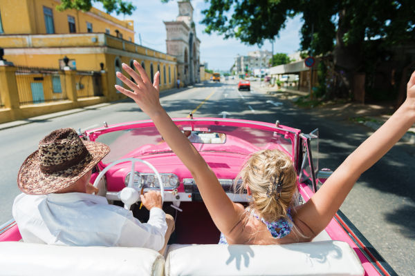 Vista trasera de amigos disfrutando en un auto convertible en La Habana, Cuba.