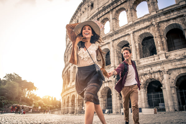 Pareja de turistas recorriendo el Coliseo en Roma, Italia.