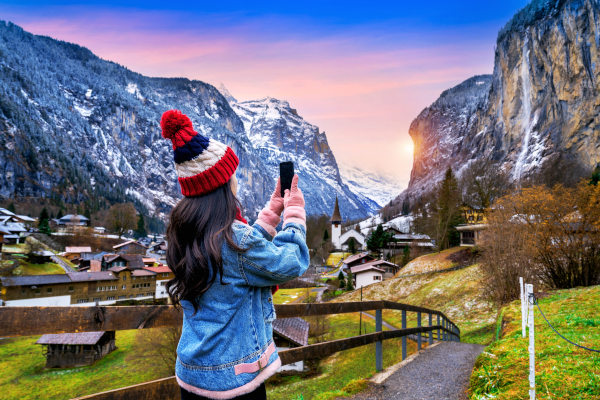Turista tomando fotos del pueblo de Lauterbrunnen en el Oberland Bernés, Suiza.