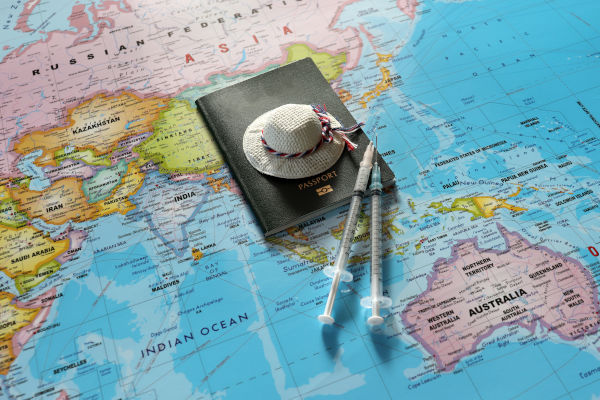 Foto con mapas, pasaporte y vacunas para viajar.