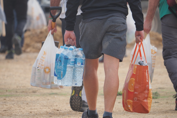 Voluntarios llevando botellas de agua y bolsas con alimentos para las víctimas de la inundación en Valencia, España, en octubre de 2024.