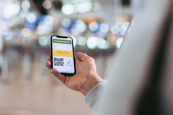 Viajero viendo un certificado de vacunación o pasaporte sanitario con QR en el smartphone.