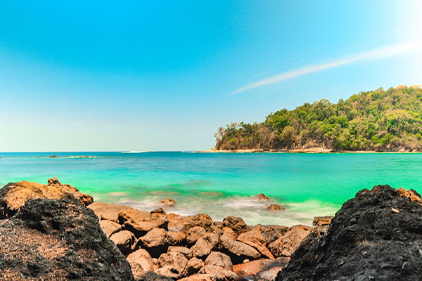 Playa en Costa Rica con piedras y bosque de fondo